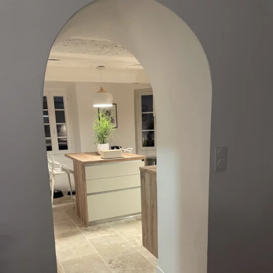 Cuisine équipée dans une petite maison de village charmante et authentique. Cuisine contemporaine, laqué mat lin soutenue par un plan de travail imitation bois.