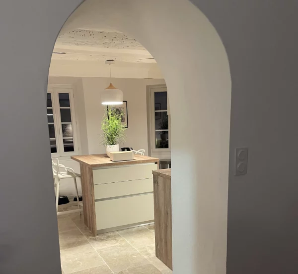 Cuisine équipée dans une petite maison de village charmante et authentique. Cuisine contemporaine, laqué mat lin soutenue par un plan de travail imitation bois.