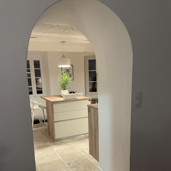 Cuisine équipée dans une petite maison de village charmante et authentique. Cuisine contemporaine, laqué mat lin soutenue par un plan de travail imitation bois.